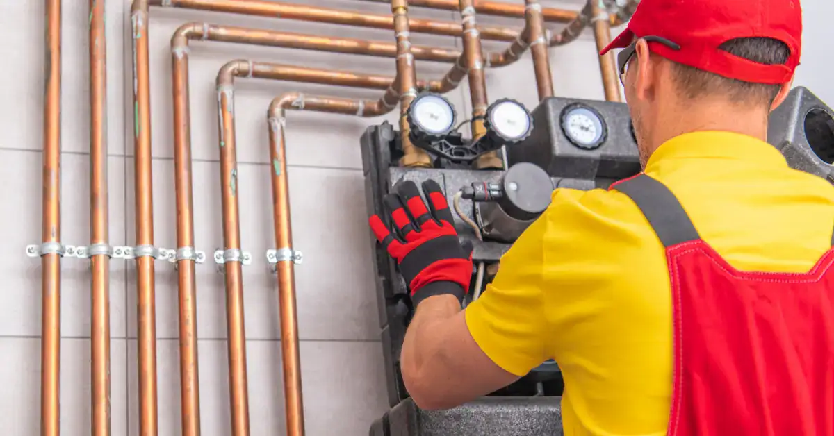 Plumber inspecting water system and pipes during summer plumbing maintenance in Champaign IL